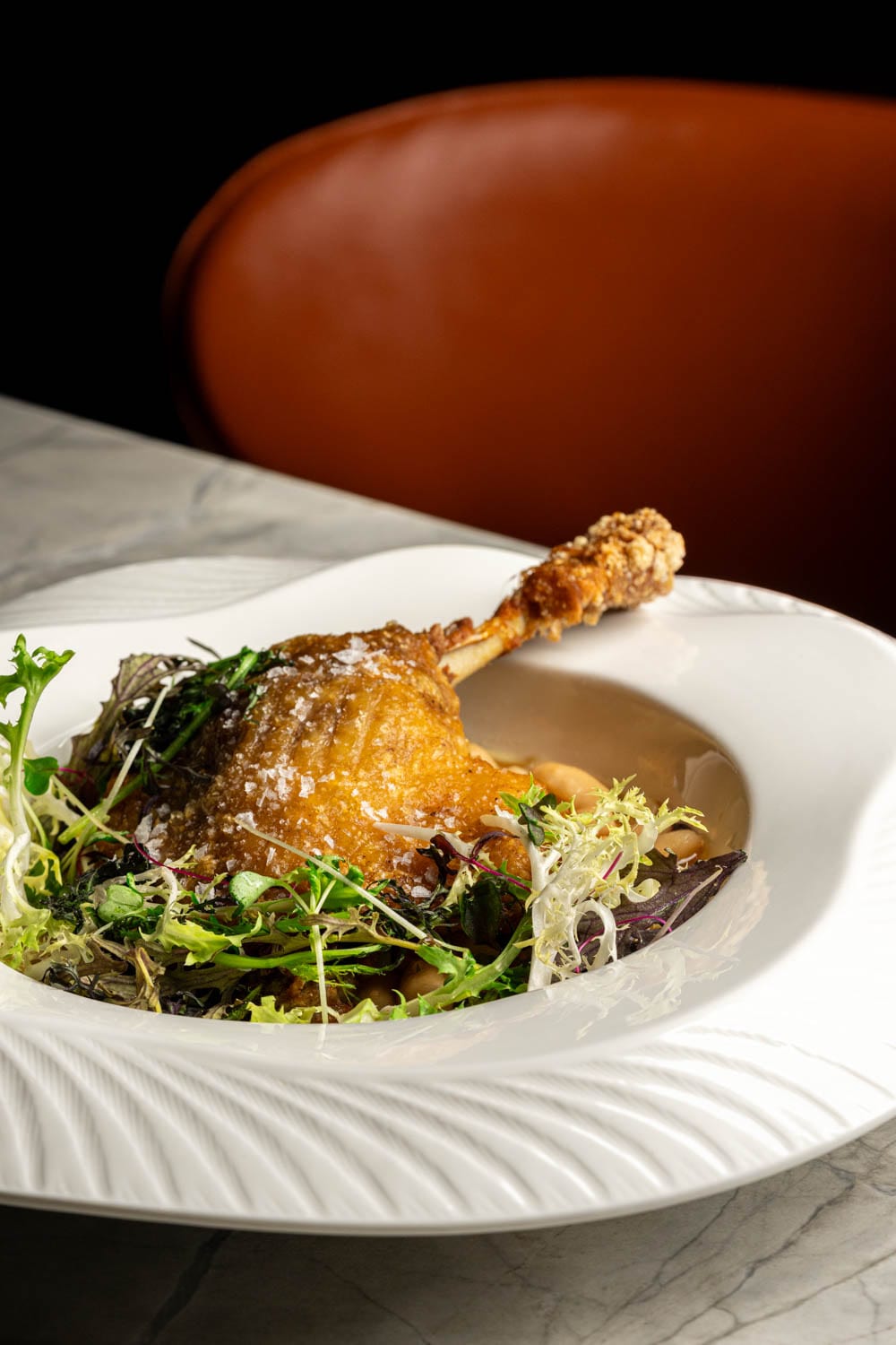 Duck confit with white beans and frisée at Restaurant Lucie