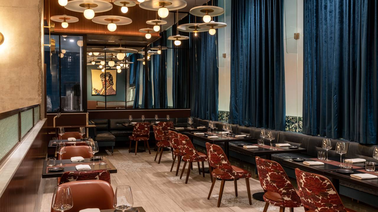 Main Dining Room at Restaurant Lucie with deep blue drapes and warm pendant lighting